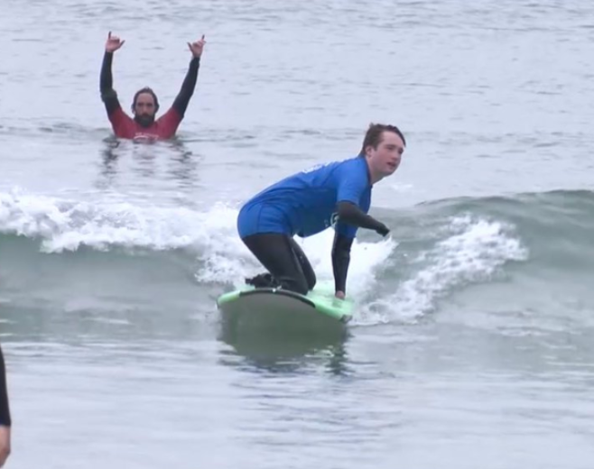 Surf Education Academy teaching an adaptive surf lesson with an adaptive surfer at La Jolla Shores beach in San Diego California