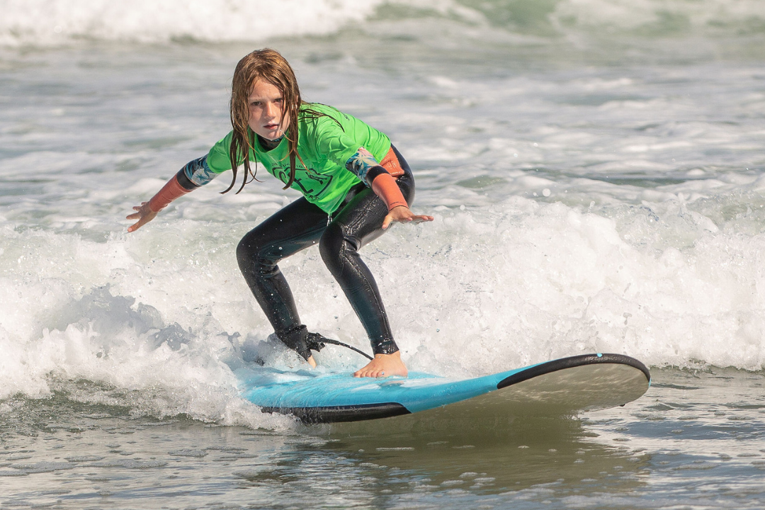 Pre teen surfing at Surf Education Academy surf camp in San Diego at La Jolla Shores